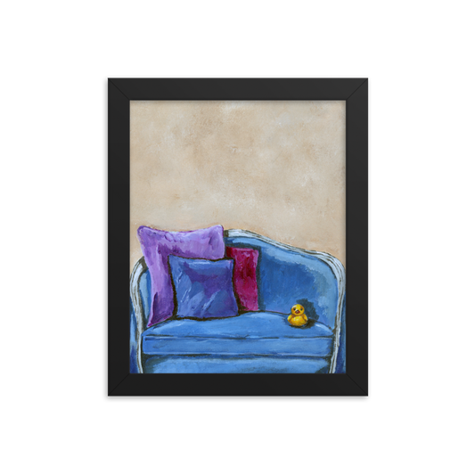 8x10 Framed print of a rubber duck sitting in a blue upholstered chair. Framed in black