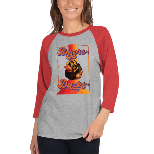 woman wearing a red sleeve, gray centered raglan shirt with a vintage 1970's design that says "Bmore Ducks" and features a Maryland flag rubber duck