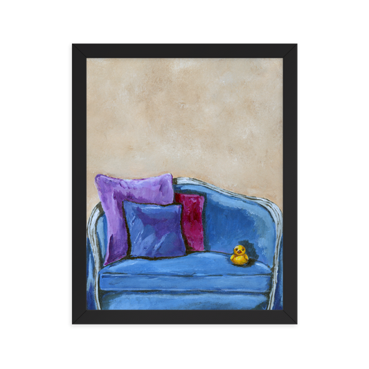 11x14 Framed print of a rubber duck sitting in a blue upholstered chair. Framed in black