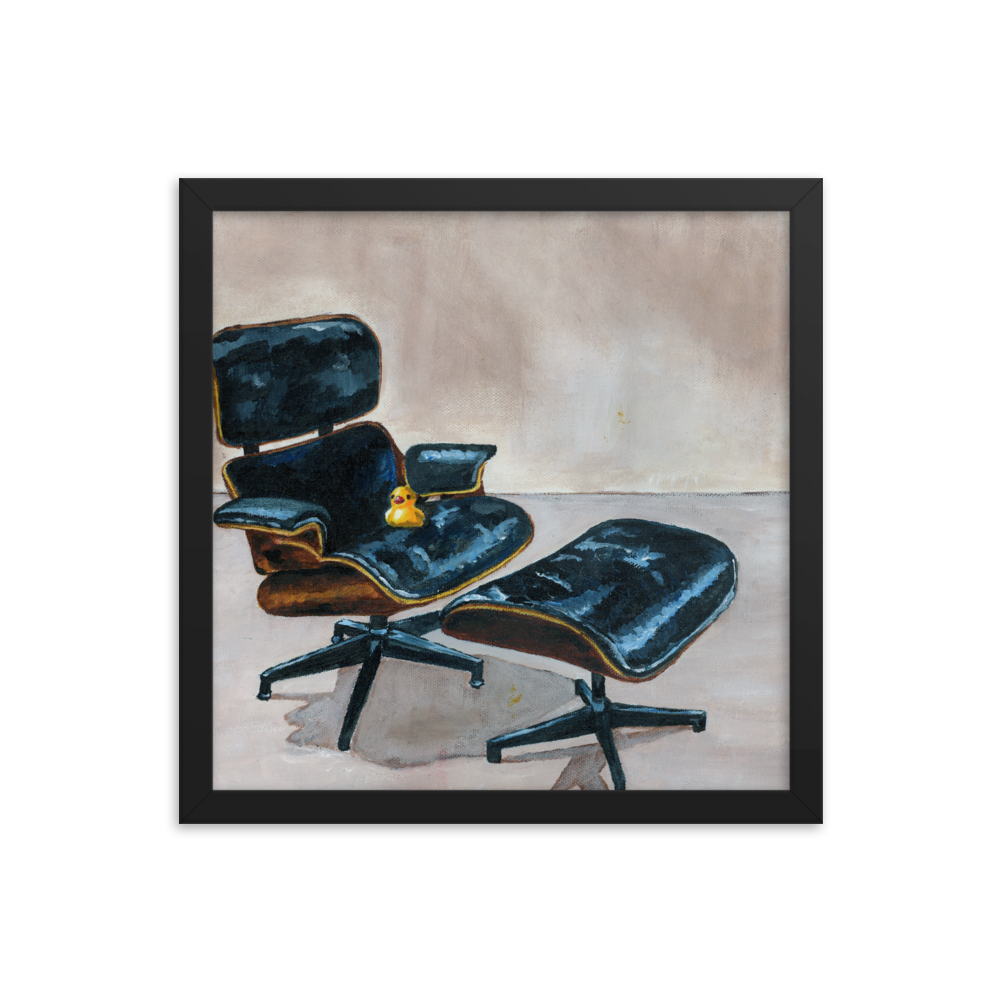 14x14 Framed print of a rubber duck sitting in a black Eames chair. Framed in black