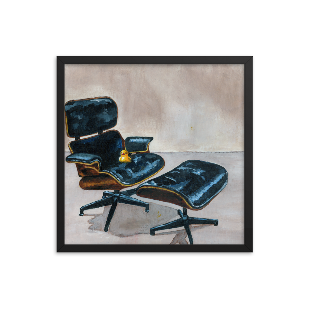 18x18 Framed print of a rubber duck sitting in a black Eames chair. Framed in black