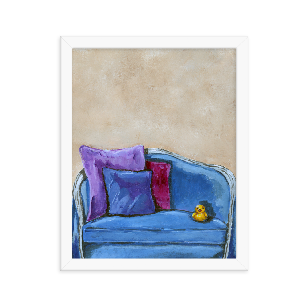 11x14 Framed print of a rubber duck sitting in a blue upholstered chair. Framed in white