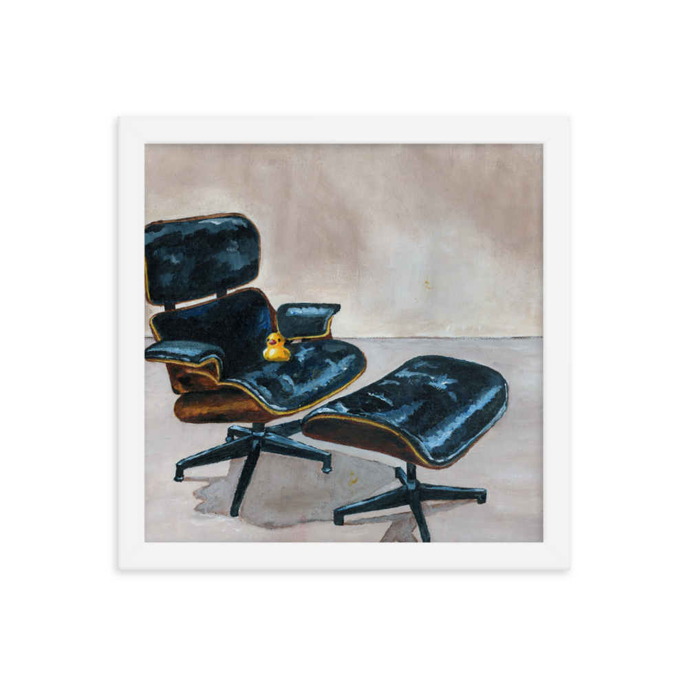 12x12 Framed print of a rubber duck sitting in a black Eames chair. Framed in white