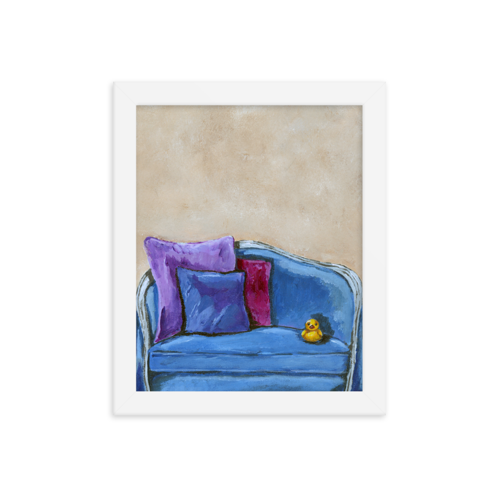 8x10 Framed print of a rubber duck sitting in a blue upholstered chair. Framed in white