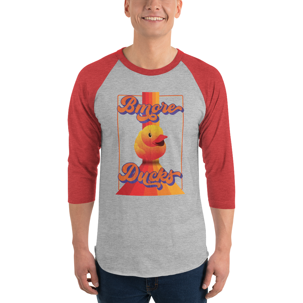 man wearing a red sleeve, gray centered raglan shirt with a vintage 1970's design that says "Bmore Ducks" and  features a yellow rubber duck