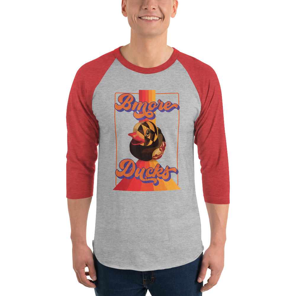 man wearing a red sleeve, gray centered raglan shirt with a vintage 1970's design that says "Bmore Ducks" and  features a Maryland flag rubber duck