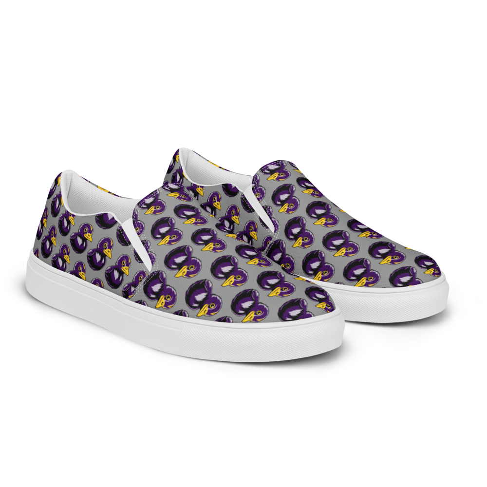 front right angle view of womens canvas slip on shoes with black and purple rubber duck patterned over gray background